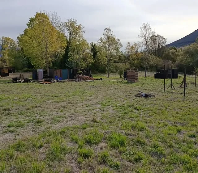 Campo abierto de airsoft en Navarra con barricadas y monte al fondo